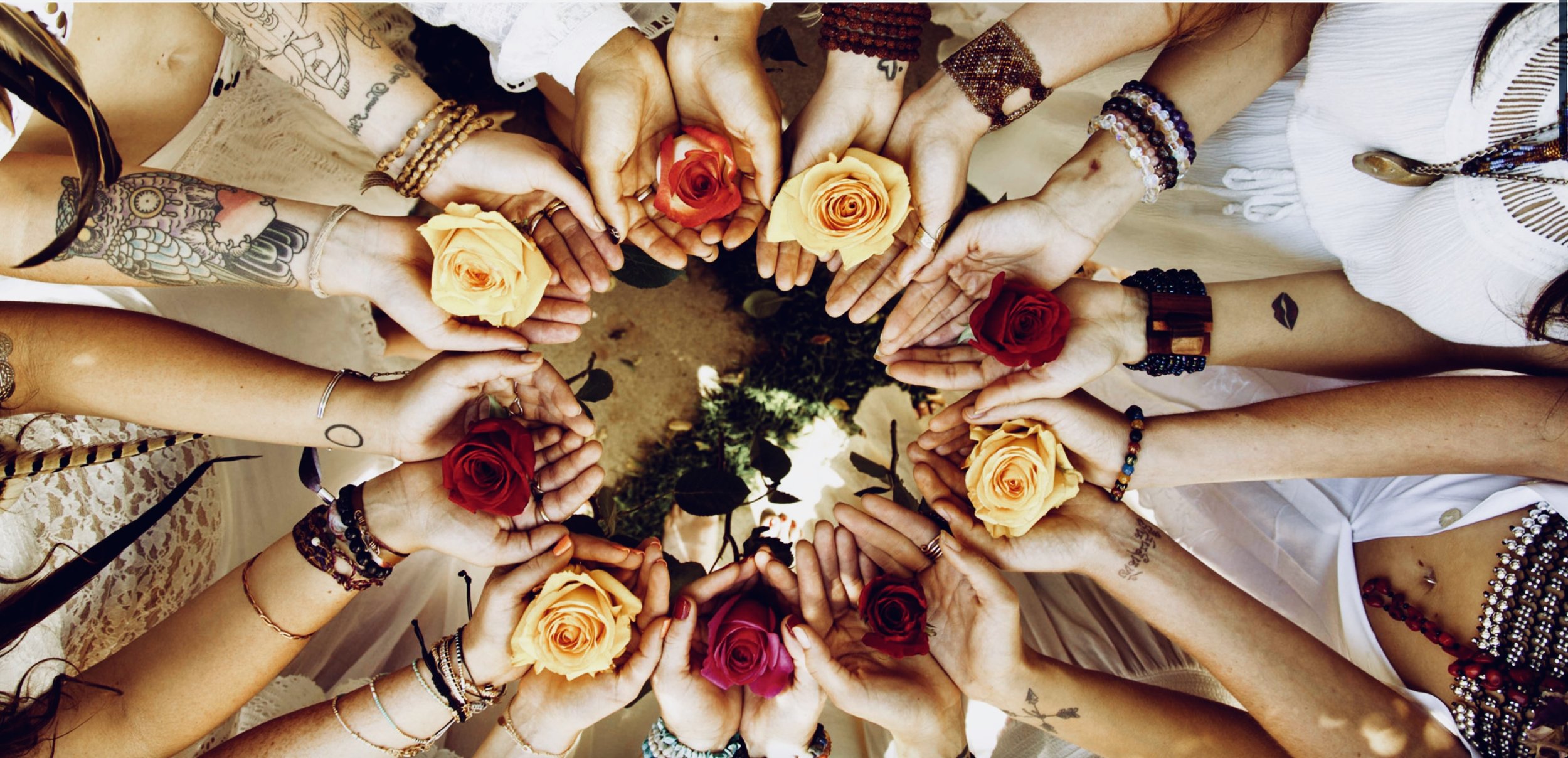 Circle of hands holding roses